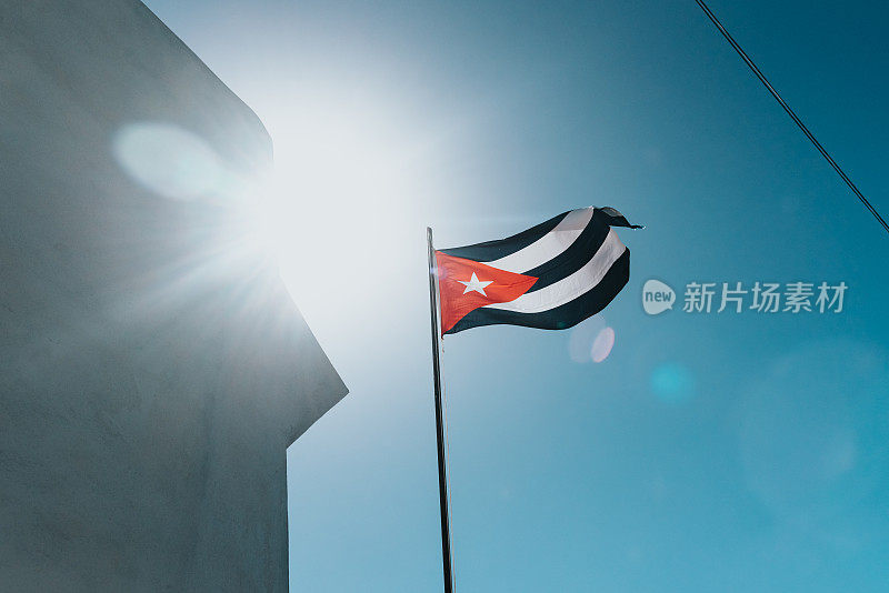 一面古巴国旗在蓝天的映衬下闪闪发光