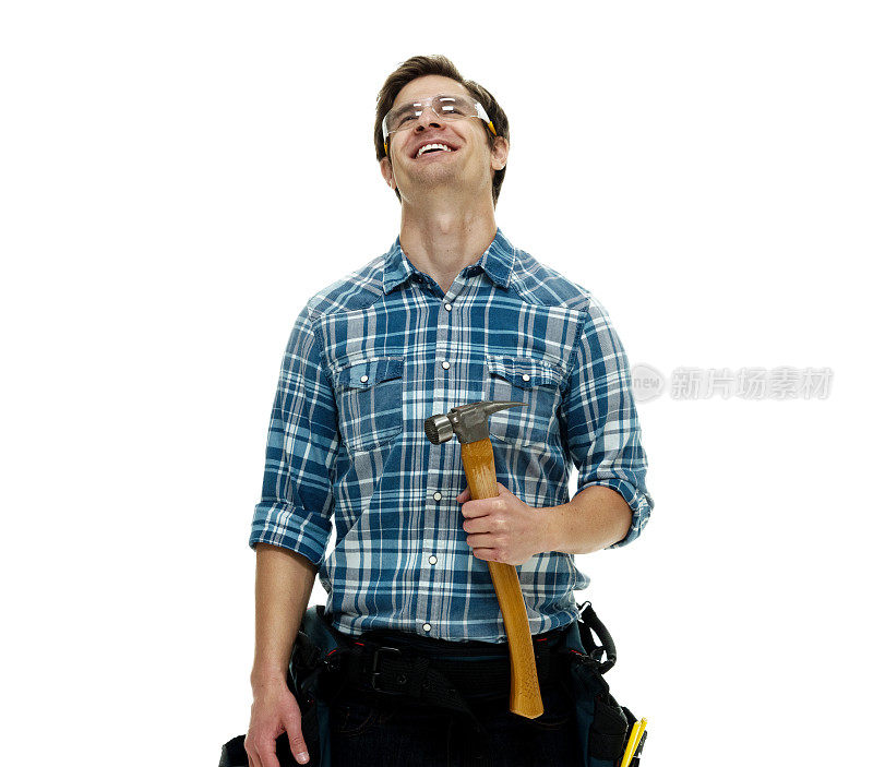 白人年轻男性建筑工人站在白色背景下，穿着牛仔裤，手持锤子