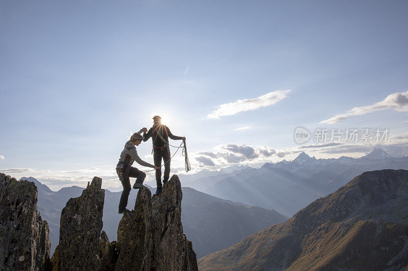 登山运动员爬上岩石的顶峰