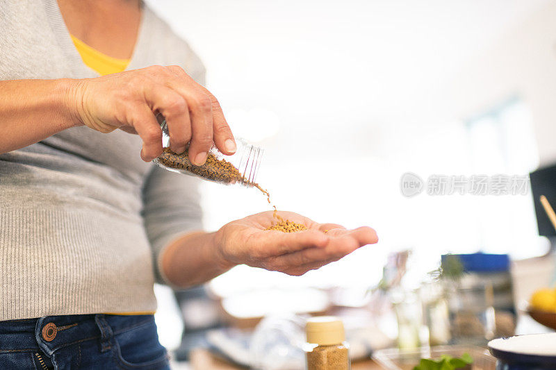 女子把胡芦巴种子倒在手里