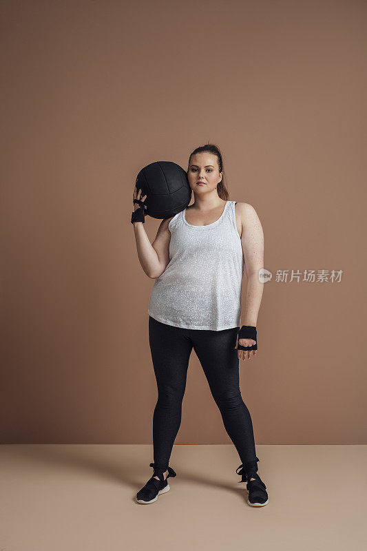 健身房减肥:大码女子摆姿势与药球