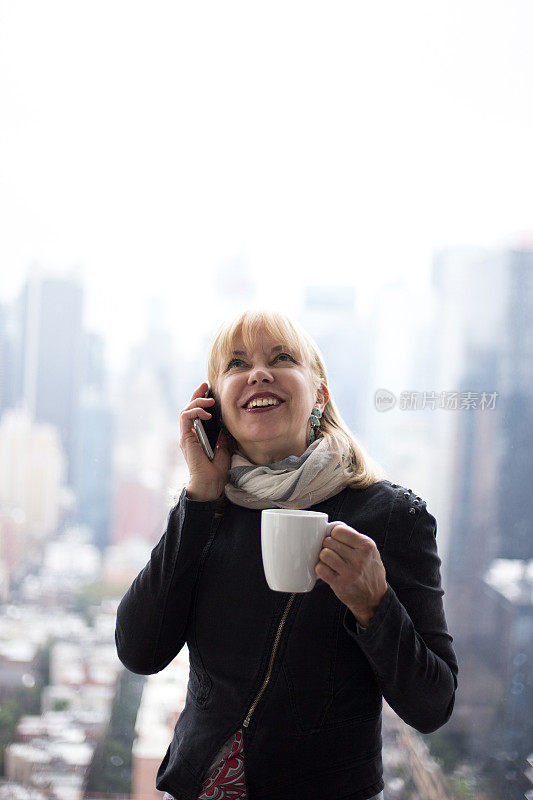 在曼哈顿办公室与城市天际线通电话的女人