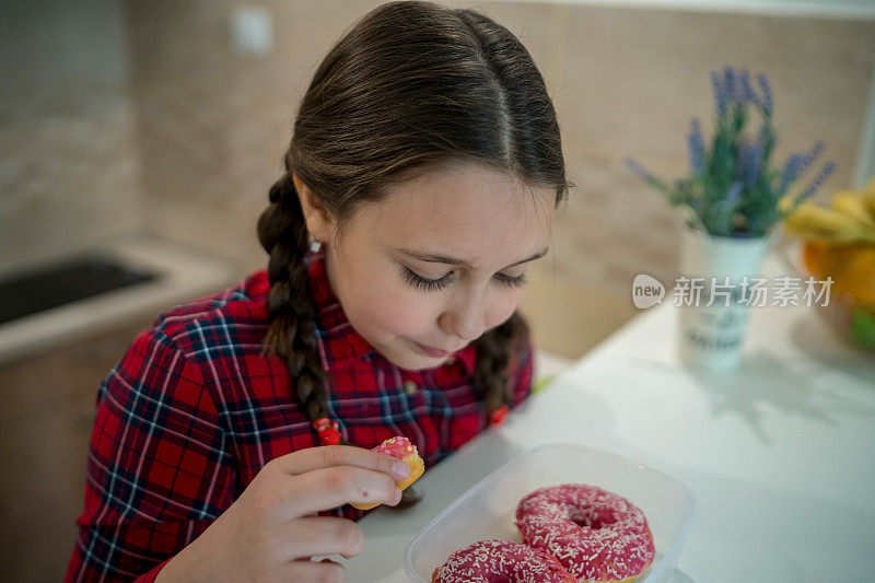 快乐的女孩吃着美味的甜甜圈