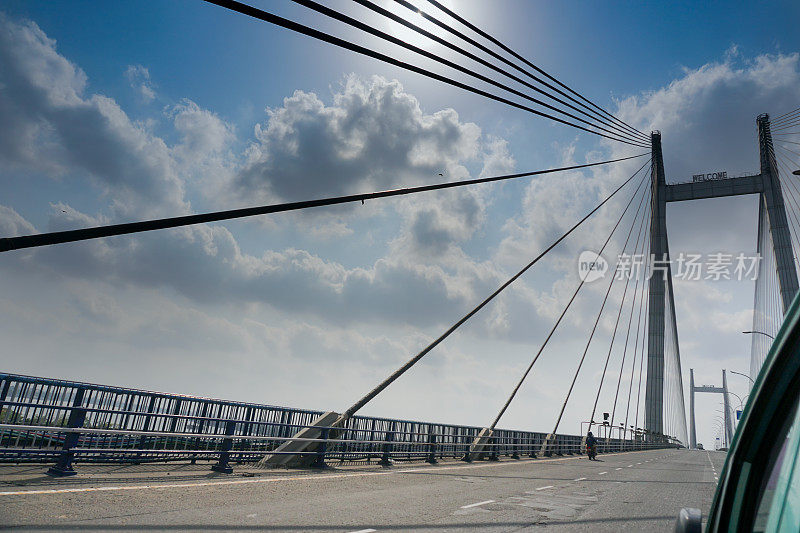 印度西孟加拉邦加尔各答虎格利第二桥上空，阳光穿过白云。