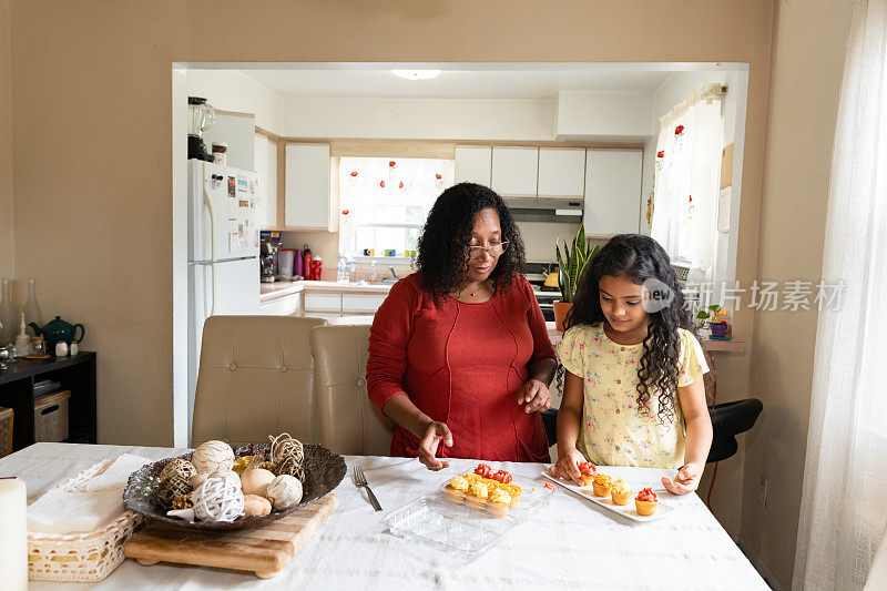 黑人姨妈和侄女在家里安排纸杯蛋糕