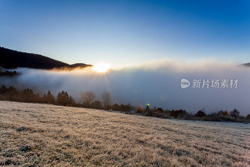 太阳从山后升起，雾在夏季清晨的黎明升起。清晨的雾消散在喀尔巴阡山脉。自然山水，自然风光，田园背景