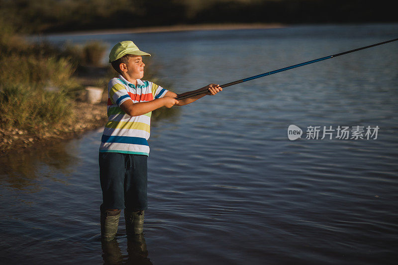 一个男孩在河边钓鱼