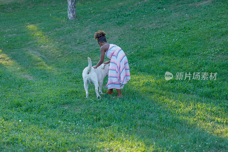 非洲小女孩和她的狗玩得很开心。