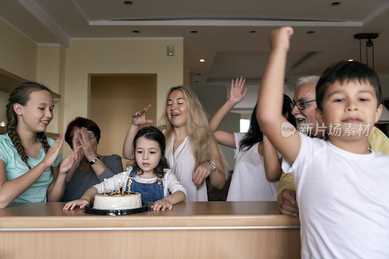 一个欢乐的几代同堂的家庭正在庆祝一个小女孩的生日。