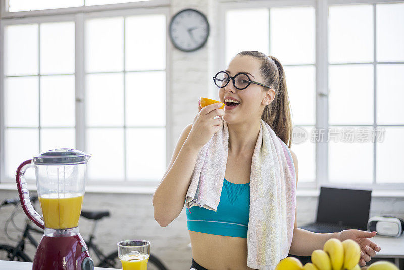 一个迷人的女人在锻炼后做了一杯清爽的冰沙