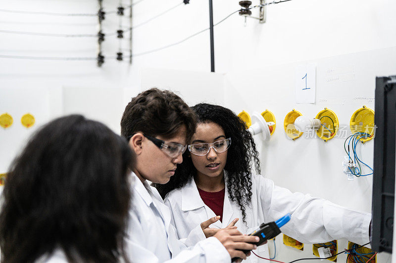 学生在电子实验室使用测量仪器