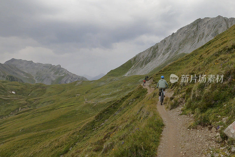 一名女子沿着阳光明媚的山脊骑山地车