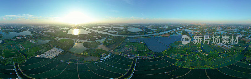 鸟瞰图的太阳能电池板在一个湖泊在农村城镇，中国