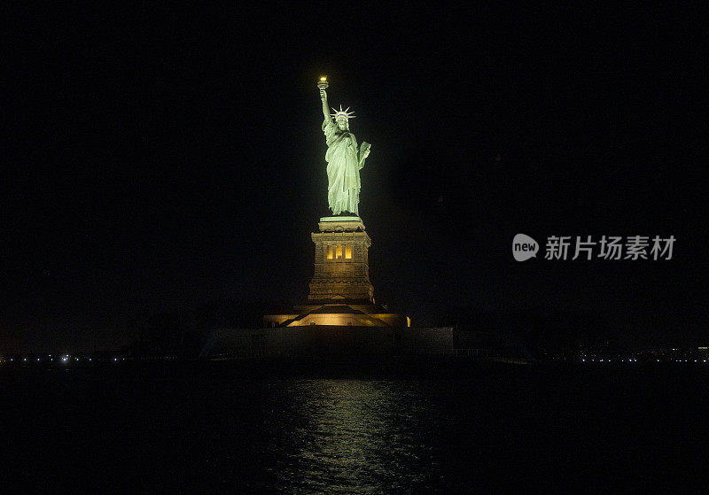 纽约的自由女神像在夜晚被聚光灯照亮