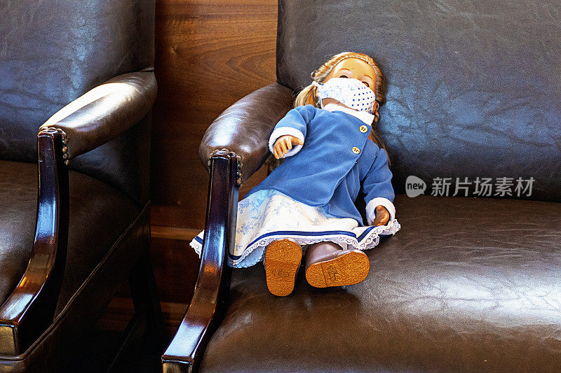 皮制座椅上的娃娃带着面具