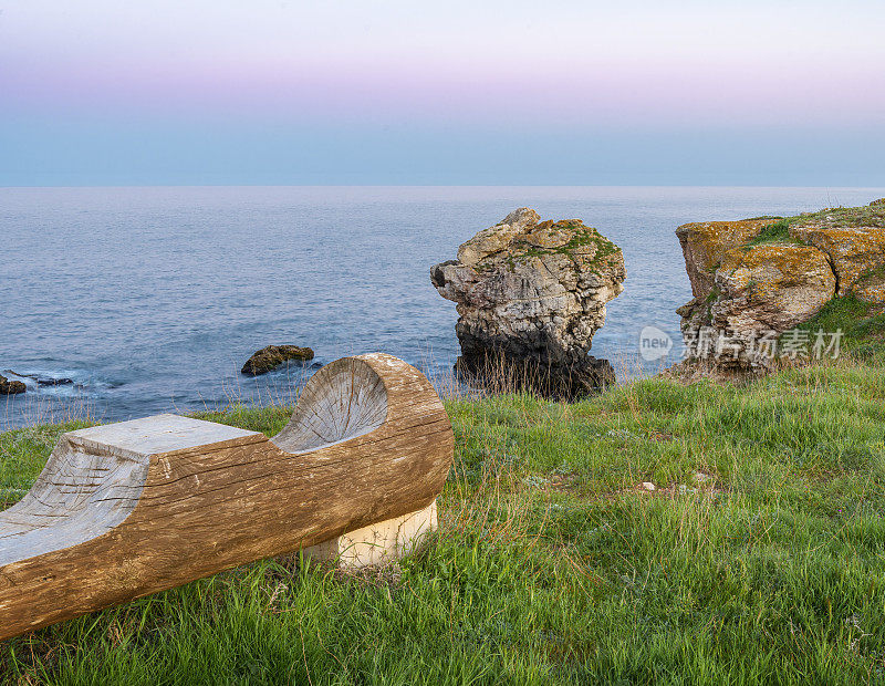 日落前，在黑海图伦诺沃村附近的岸边和孤独的岩石上坐着