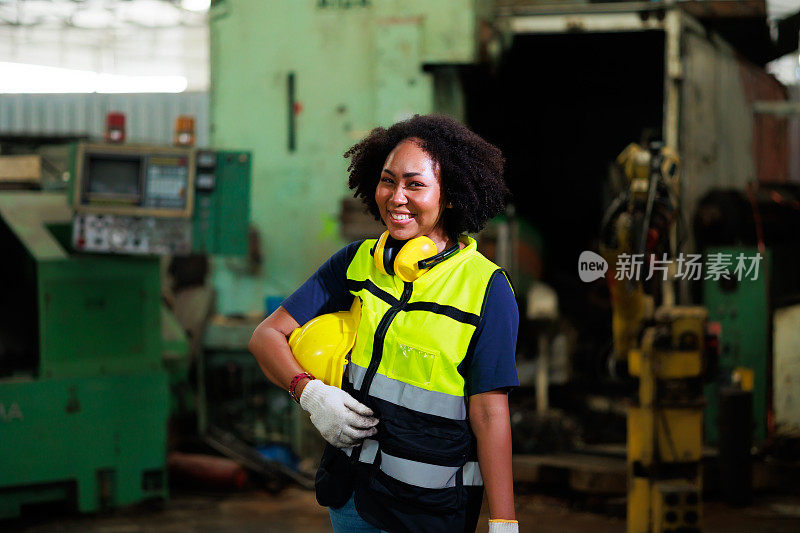 肖像非裔美国女工程师戴安全帽安全帽。金属车床工业制造厂