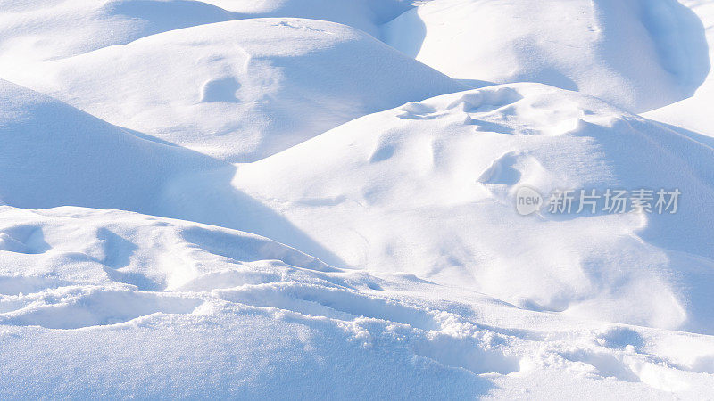 雪漂移的背景拼贴。苍翠的雪堆在一个晴朗的冬日接近。一场暴风雪过后，山上覆盖了一层厚厚的雪。