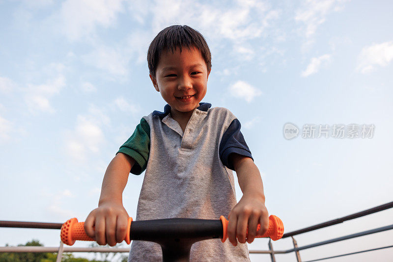 这个小男孩正在学骑自行车