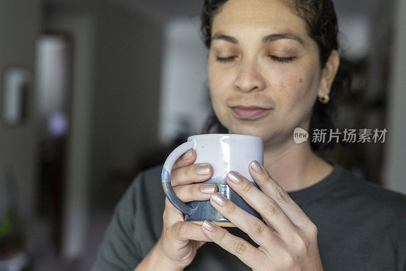 拿着一杯茶的拉丁妇女