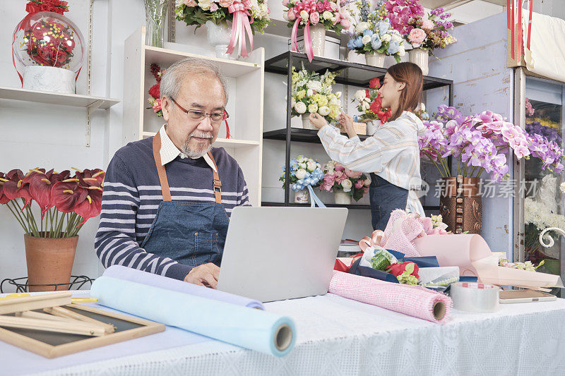 亚洲年长的男性老板和年轻的女性员工在五颜六色的花店工作。