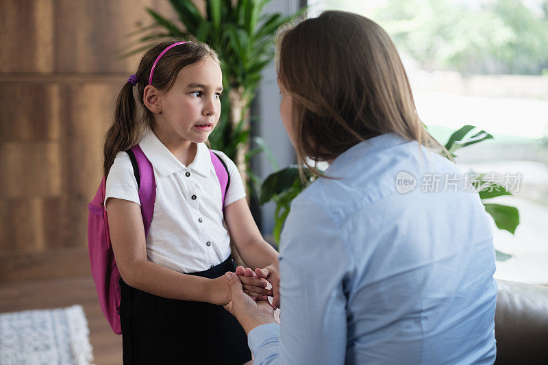 回到学校的概念。母亲在女儿第一天上学时安慰她。