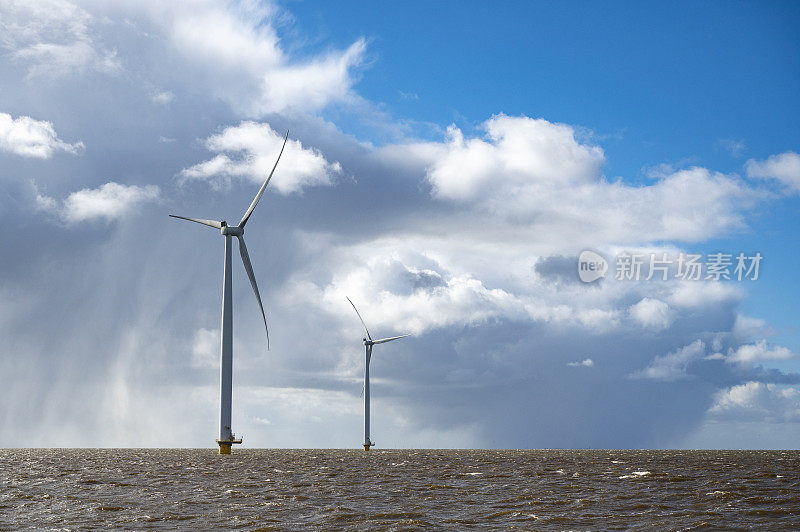 海上风力涡轮机，背景是暴风雨般的蓝天。