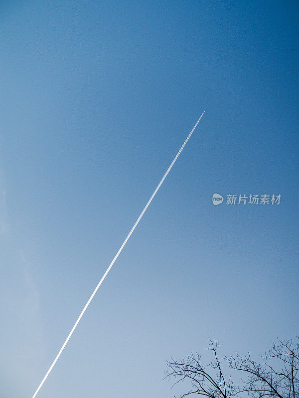 极简主义者。一架飞机在开阔的天空中飞行，留下了它的喷气痕迹。