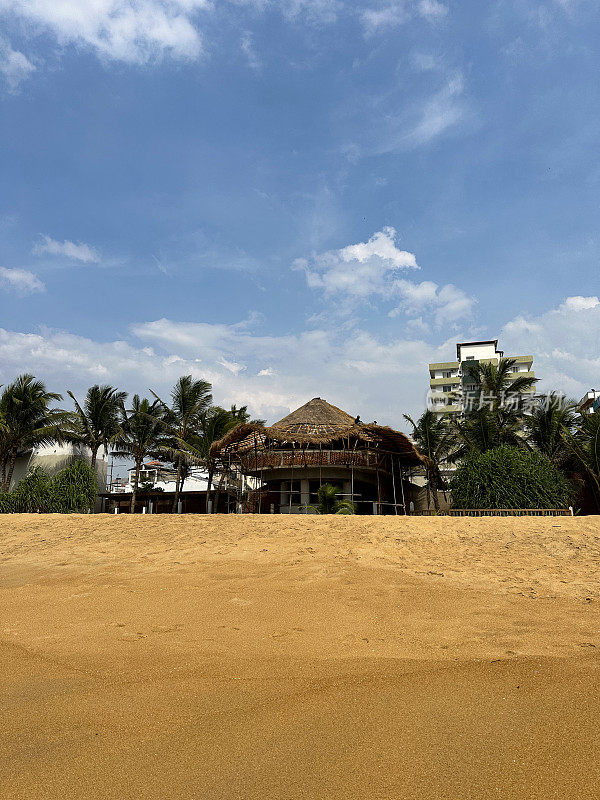 斯里兰卡科伦坡拉维尼亚山海滩海滨的海滩房屋和酒店图片，正在建造的海滩房屋，茅草屋顶