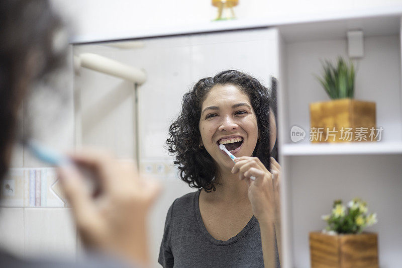 拉丁女人在浴室里愉快地刷牙