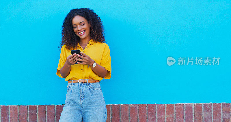 手机，微笑和年轻女子在社交媒体，移动应用程序或互联网上的一个滚动墙。快乐，兴奋和女性的人从哥伦比亚在手机上的蓝色背景与模型空间。