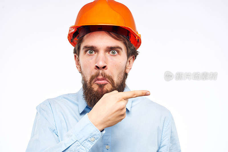 一个穿着工作服的情绪化的男人用他的手比划着一个正式的建筑专业人员