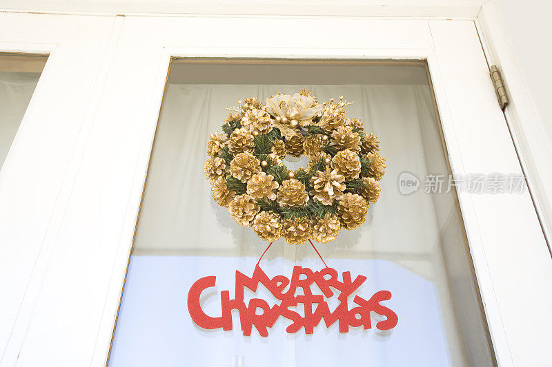 圣诞花环和装饰品拼写圣诞快乐在门上