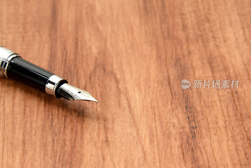 钢笔放在木桌上
