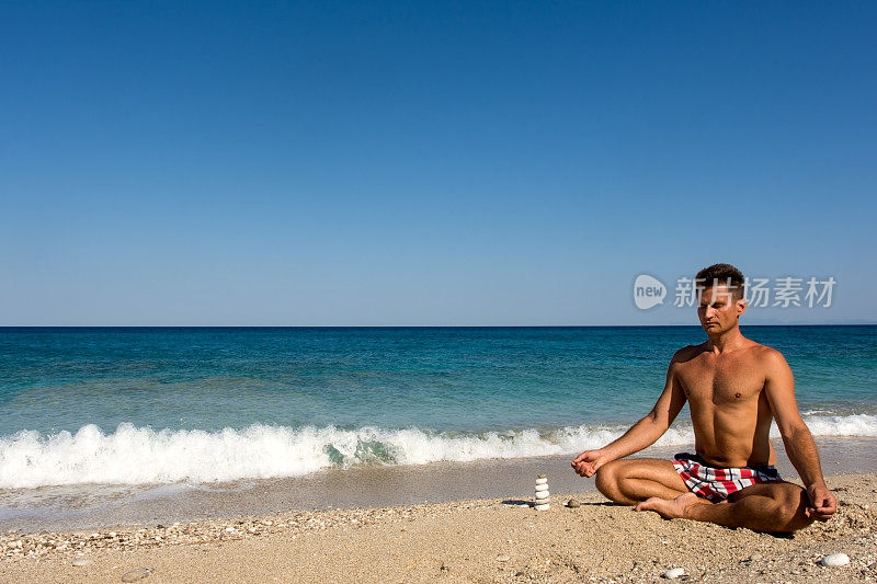清晨，成年男性在海滩上进行冥想练习