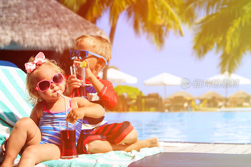 孩子们在热带海滩度假胜地放松和喝果汁