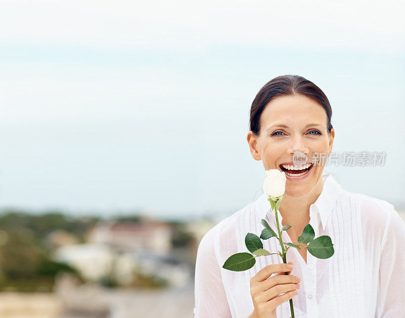中年女人捧着一朵花笑着
