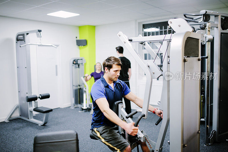 在健身房里使用负重器械进行锻炼