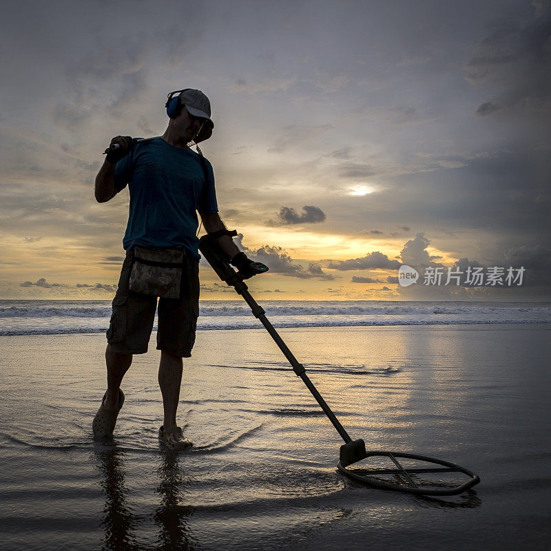 海滩上的寻宝人，带着金属探测器