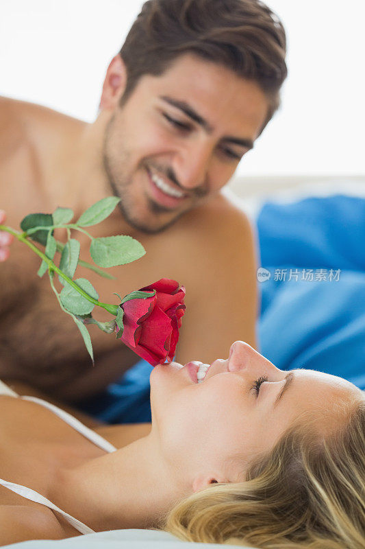 男友手捧红玫瑰抚摸女友的下巴