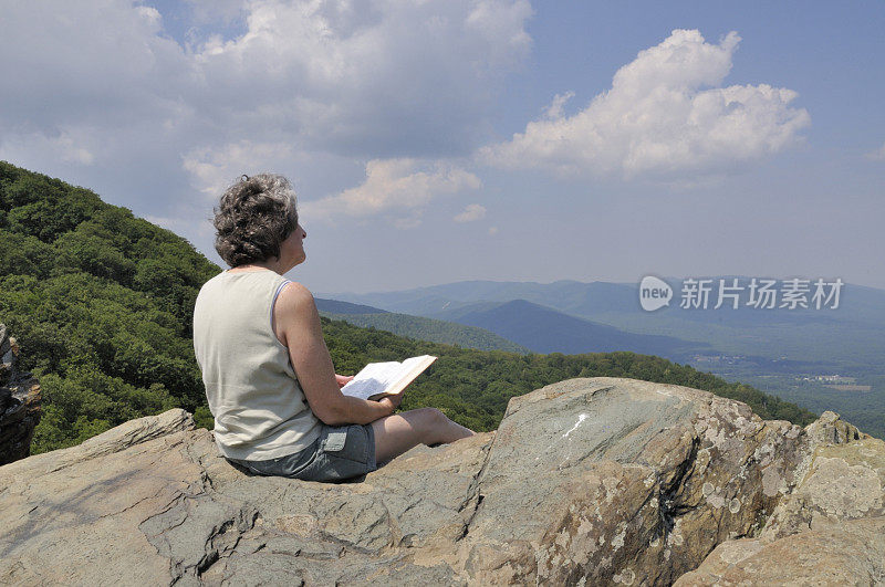 在山顶上学习圣经的徒步旅行者