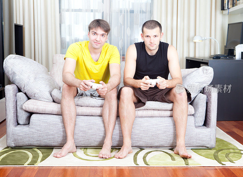 两个男人在沙发上玩电子游戏