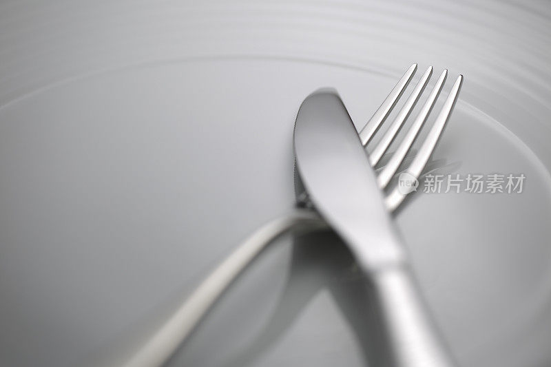 勺叉刀放在白色盘子上
