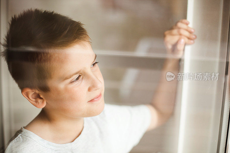 一个男孩从窗户往里看的肖像