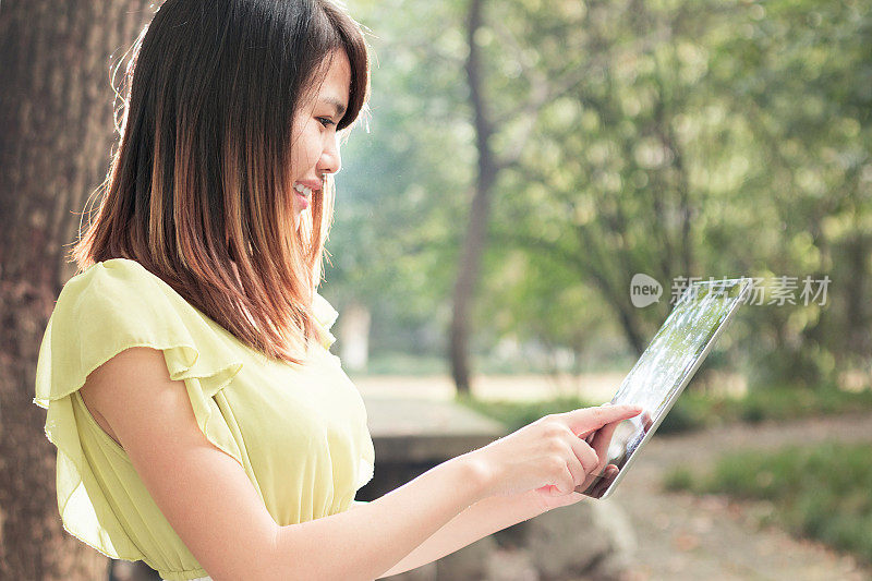 亚洲女学生在校园里用平板电脑的肖像