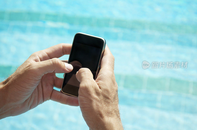 手握空白智能手机在游泳池