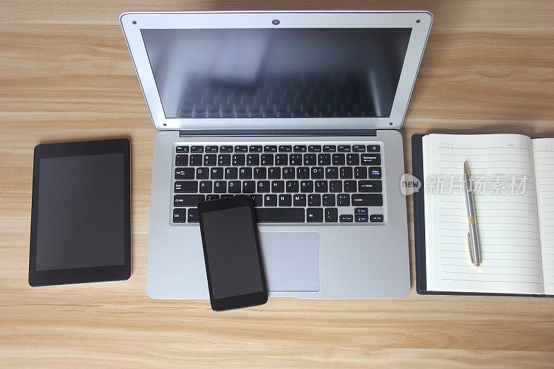 桌上有笔记本电脑、平板电脑、笔记本电脑和手机