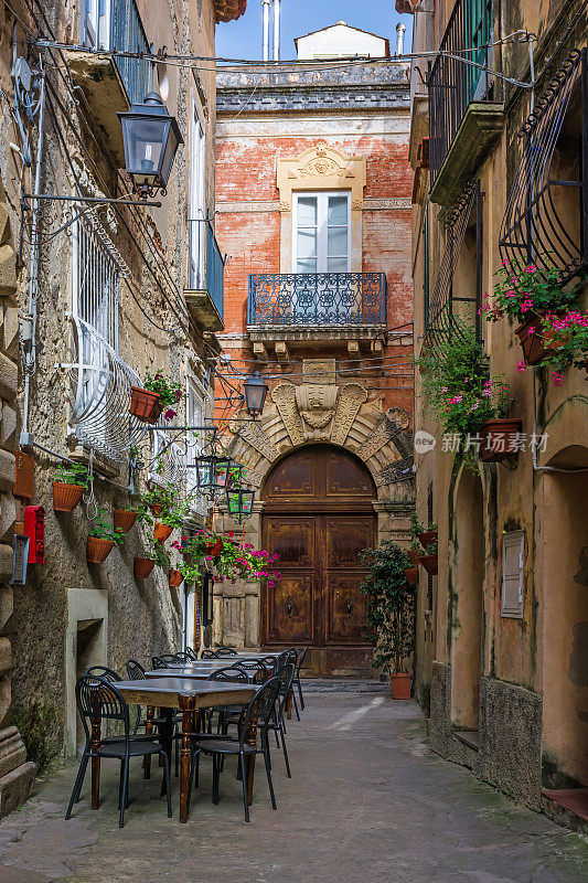 意大利波西塔诺镇舒适的街道上，咖啡馆的桌椅