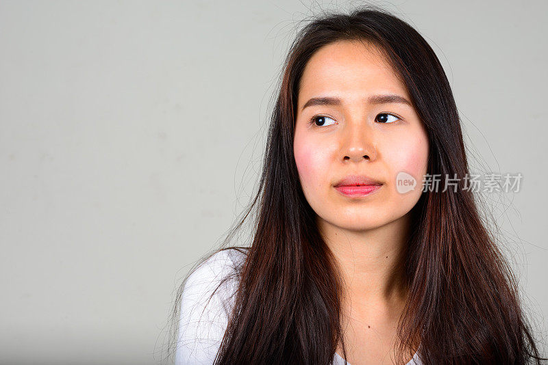 年轻美丽的亚洲女人长直发对抗白色的背景