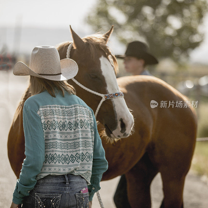 在一个牧场上，两个十几岁的男孩和女孩正准备去骑马。